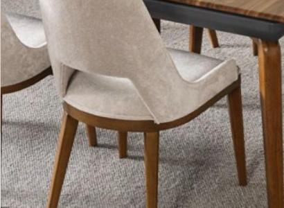 A laconic, modern chair with high wooden legs and upholstery in a pleasant, light cream color for the dining room